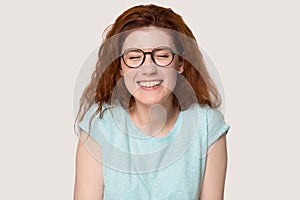 Happy red-haired girl in glasses laugh at funny joke