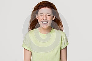 Happy red-headed woman screaming with laughter isolated on background