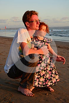 Happy redhead family on the sunset beach