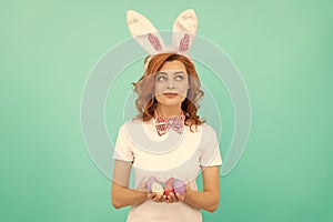 happy redhead girl in bunny rabbit ears with painted eggs, easter hunt