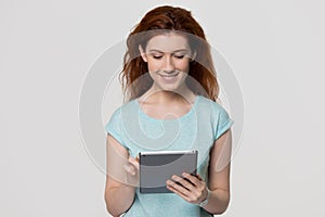 Happy redhead woman using digital tablet isolated on background