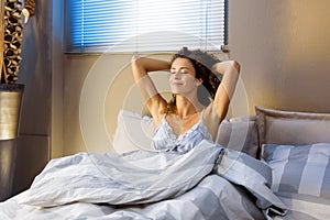 Happy refreshed young woman waking from a sleep photo