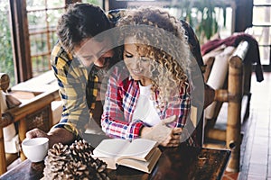 Happy relationship couple of adult at home reading a book and enjoy time together. Indoo rleisure activity man and woman in living