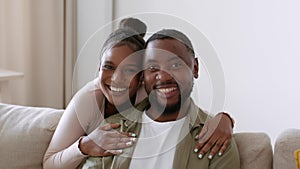 Happy relationships. Young african american man and woman smiling to camera together, embracing at home, free space