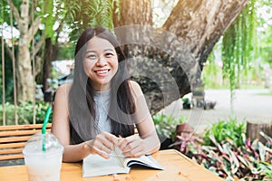 Happy relax times with reading book, Asian women Thai teen smile with book in garden