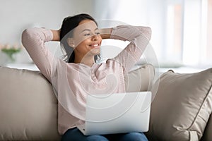 Happy relaxed female student, freelancer, customer relaxing on couch