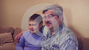 Happy relaxed man resting on the sofa with his son,