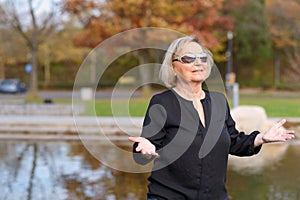 Happy relaxed senior woman celebrating the fall