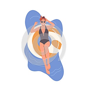 Happy relaxed woman floating in inflatable rubber ring in swimming pool or sea ocean water