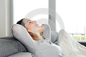 Happy relaxed woman resting on a couch at home