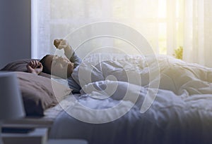 Happy relaxed woman waking up early in the morning