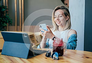 Happy relaxed young woman chatting on the phone while sitting in a cafe.