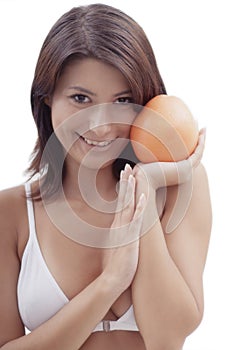 Happy relaxing girl with an orange fruit