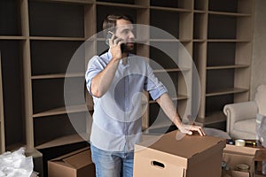 Happy renter man, apartment buyer talking on mobile phone