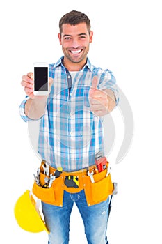 Happy repairman showing mobile phone white gesturing thumbs up photo