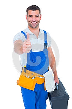 Happy repairman with toolbox gesturing thumbs up