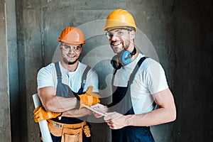 Repairmen in goggles and helmets standing in house photo