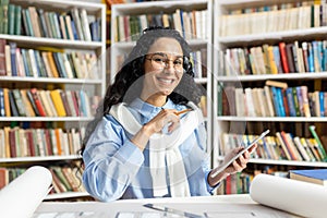 Happy researcher using smartphone in a library setting