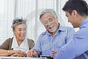 Happy retired Asian senior eldery couple consult with personal financial advisor or real estate agent. Retirement investment