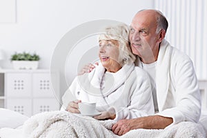 Happy retired couple in bed