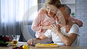 Happy retired couple hugging at home kitchen, love and harmony, cooking leisure