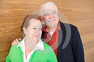 Happy Retired Couple on Wooden Wall Background