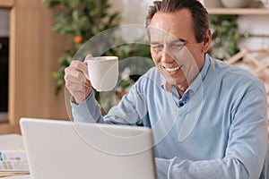 Happy retired man using electronic gadget at home