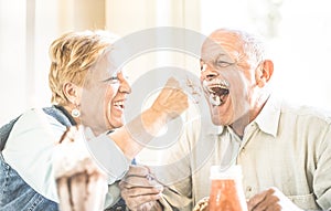 Happy retired senior couple in love enjoying bio icecream cup