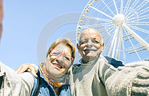 Happy retired senior couple taking selfie at winter travel trip