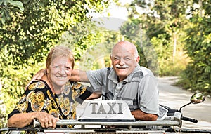 Happy retired senior couple taking travel photo at scooter taxi tour