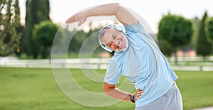 Happy retired senior man doing side stretching exercises with arm overhead during outdoor workout