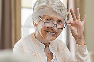 Senior woman holding eyeglasses photo