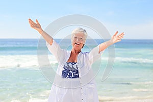 Happy retired woman on the beach