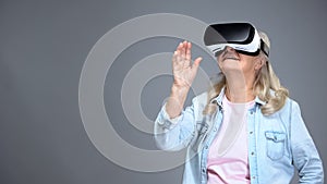 Happy retiree female wearing VR headset, modern technologies, innovations