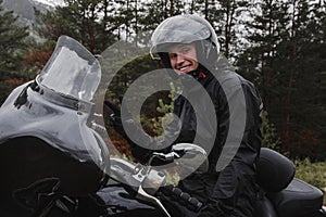 Happy rider and his black motorcycle photo
