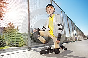 Happy roller skater posing on floor at skate park