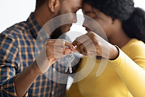 Happy Romantic Black Spouses Holding Keys From Their New Home, Closeup Shot