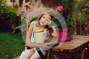Happy romantic child girl dreaming in evening summer garden