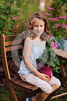 Happy romantic child girl dreaming in evening summer garden