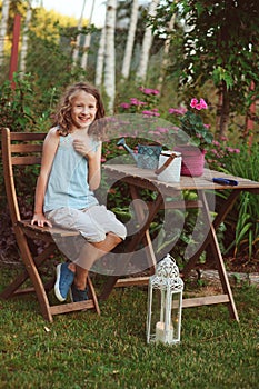 Happy romantic child girl dreaming in evening summer garden