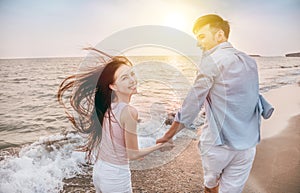 Happy and Romantic couple having fun on the beach at sunset