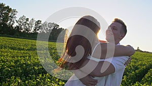 Happy Romantic couple having fun outdoors. Love. Woman is running to her man, they hug and spin around on a sunset with