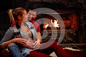Happy romantic couple hugging at home front of fireplace