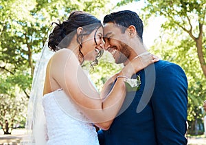 Happy romantic couple looking joyful while standing together on their wedding day. Bride and groom touching foreheads