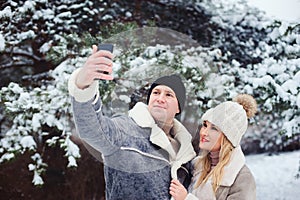 happy romantic couple making selfie outdoor in snowy winter