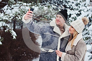 happy romantic couple making selfie outdoor in snowy winter