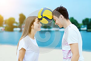 Happy romantic couple playing with soccer ball in summer