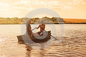 Happy romantic couple rowing a boat