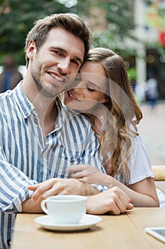 Happy romantic couple sitting at sidewalk cafe