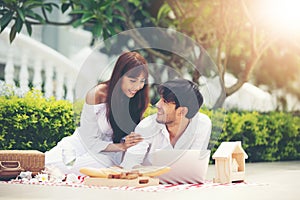 Happy Romantic Couples lover talking and drinking wine while having a picnic at home